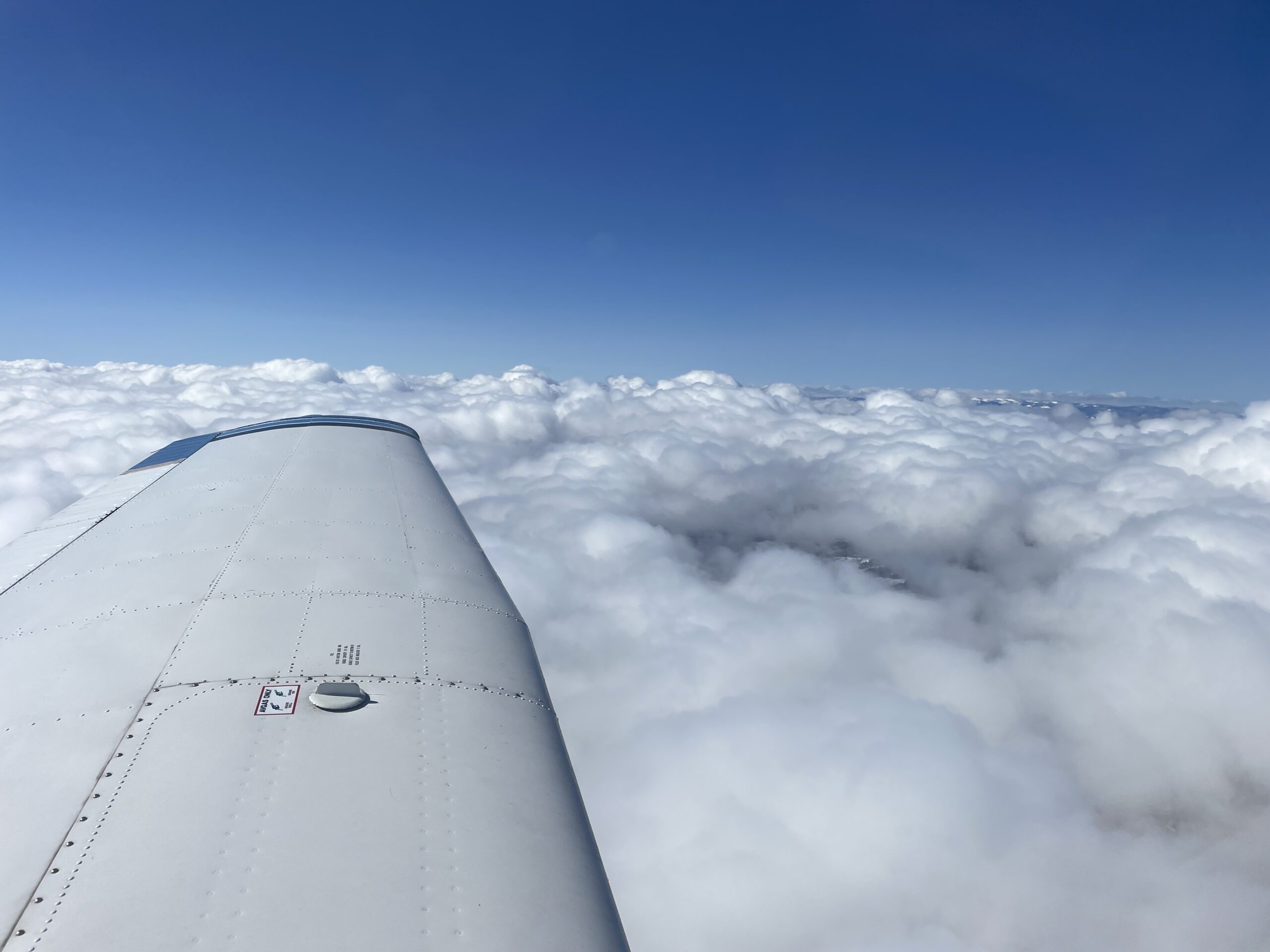 piper airplane flying above the clouds