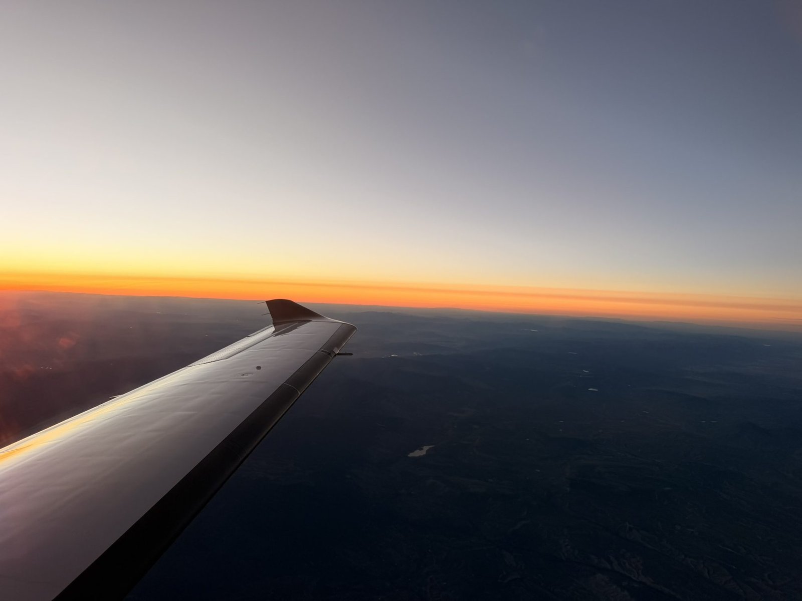 Turboprop wing against a sunset sky in flight