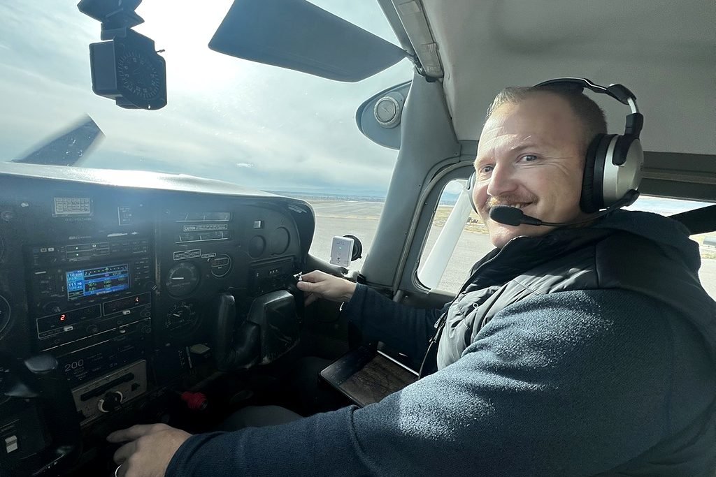 Flight instructor Adam Lendi at the controls of a Cessna in flight